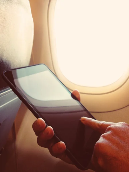 Hombre de negocios se sienta en el avión mirando su teléfono celular —  Fotos de Stock