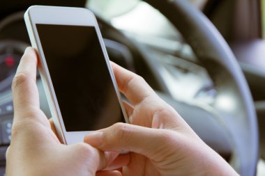 Mobil cihaz arabada tutan genç kadın
