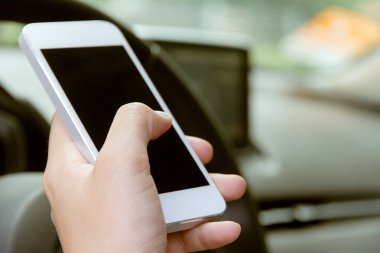 Arabada oturan ve akıllı telefon kullanan kadın