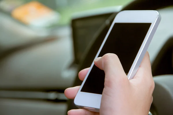 Jeune femme tenant un appareil mobile dans la voiture — Photo