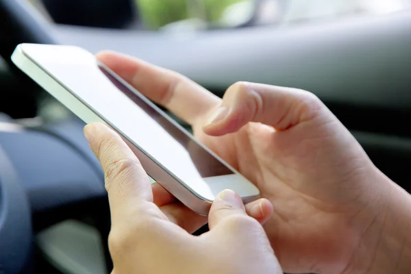 Femme assise dans la voiture et utilisant un téléphone intelligent — Photo