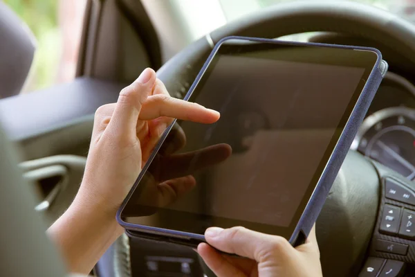 Жінка сидить в машині і використовує цифровий планшет — стокове фото
