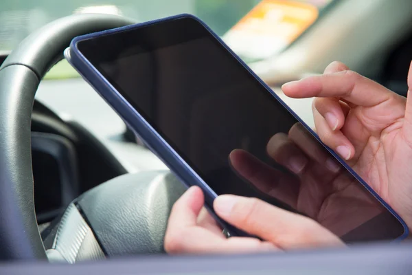 Femme assise dans la voiture et utilisant une tablette numérique — Photo