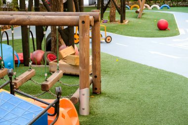Yeşil sentetik çimlerin üzerinde çeşitli ekipman ve oyuncaklarla boş oyun alanı