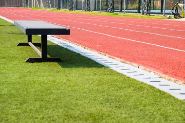 Yeşil çimenli ve kırmızı koşu parkurlu boş bank