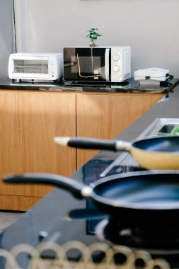 Evde mutfaktaki masada mikrodalga fırın var..