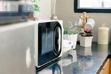 Evde mutfaktaki masada mikrodalga fırın var..