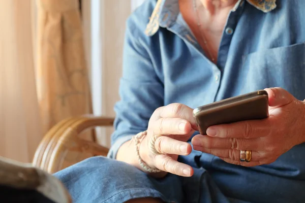 Femme plus âgée utilisant un téléphone intelligent — Photo