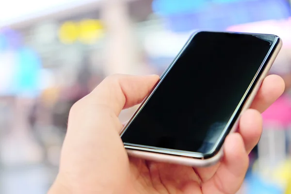 Usando un teléfono inteligente en el aeropuerto . — Foto de Stock