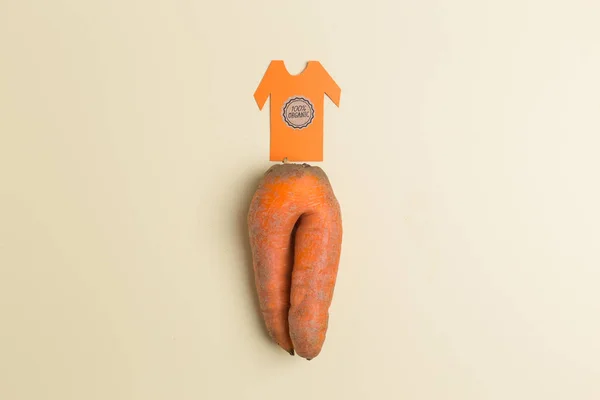 Модная уродливая органическая морковь в виде брюк с футболкой, вырезанных из бумажной креативной концепции — стоковое фото