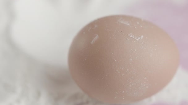 Движение свежих органических яиц на белой муке — стоковое видео