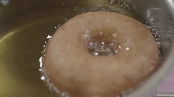 El proceso de freír las rosquillas en el aceite caliente. Concepto de cocción — Vídeos de Stock