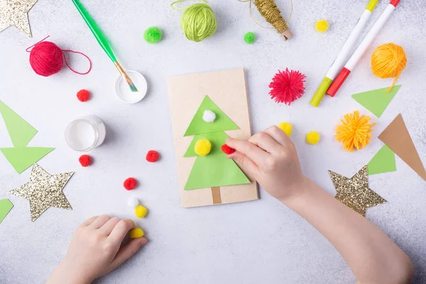 Il bambino fa un collage di carta di auguri natalizio. Progetto di arte per bambini artigianato per bambini — Foto Stock