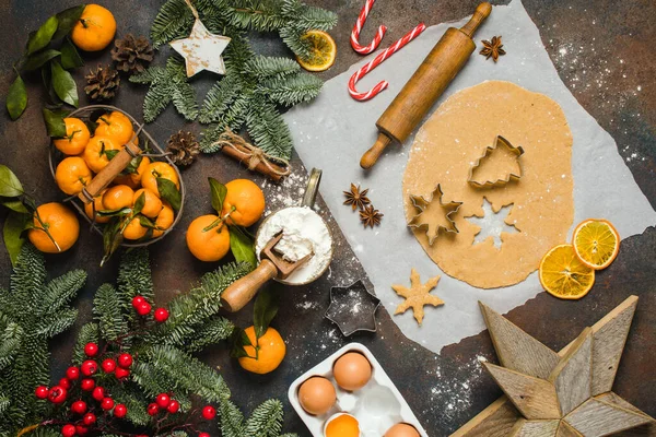 Vakantie eten. Ingrediënten voor het maken van kerst gember koekjes kleine bomen en sneeuwvlok. Mandarijnen, dennenbomen, snoepjes. — Stockfoto