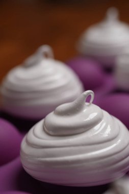 Profesyonel pasta şefi, parlak Fransız kremasını fırın tepsisine koydu. Düşük sıcaklıkta pişirmeye hazır. Klasik beyaz kremalı, mükemmel kıvrımlı, silikon hasırlar ya da fırın kağıdı üzerinde düzenli sıralanmış. Taze ev yapımı tatlı.