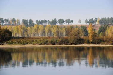 Sakin ve rahatlama, renkli ağaçların ve gökyüzünün yansıtıldığı, su yüzeyinin şaşırtıcı sonbahar manzarasından kaynaklanır..