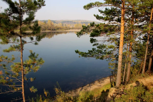 Sonbaharda dik kıyıdan nehrin sakin yüzeyinin görüntüsü.