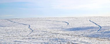 Karlı bir arazinin inanılmaz manzarası tekerlek izleriyle kaplı..