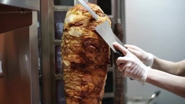 Bir aşçı shawarma, gyros, doner kebap yapmak için et keser..