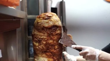 Bir aşçı shawarma, gyros, doner kebap yapmak için et keser..