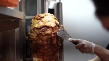 Bir aşçı shawarma, gyros, doner kebap yapmak için et keser..