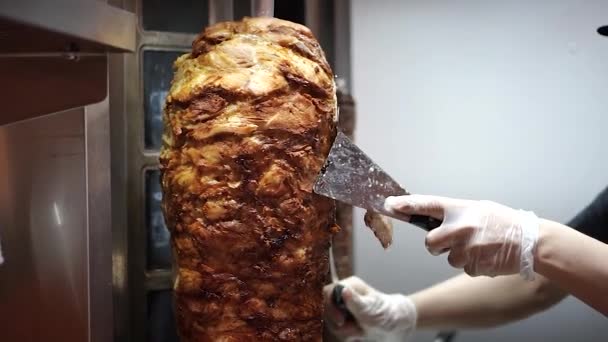 Ein Koch schneidet Fleisch für Shawarma, Gyros und Dönerspieße. — Stockvideo