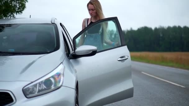 Giovane donna si mette al volante di una macchina — Video Stock