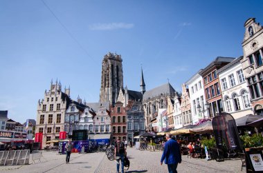 Mechelen, Belçika, Ağustos 2019. Büyük meydan: Grote Markt. Katedralin çan kulesi buradaki en güzel binaların ön cephesinde duruyor. Restoranlar ve insanlar.