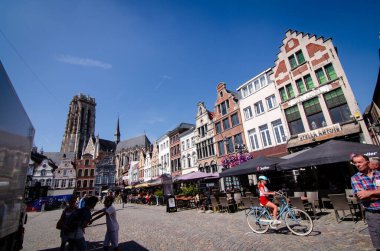 Mechelen, Belçika, Ağustos 2019. Büyük meydan: Grote Markt. Katedralin çan kulesi buradaki en güzel binaların ön cephesinde duruyor. Restoranlar ve insanlar.