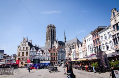 Mechelen, Belçika, Ağustos 2019. Büyük meydan: Grote Markt. Katedralin çan kulesi buradaki en güzel binaların ön cephesinde duruyor. Restoranlar ve insanlar.