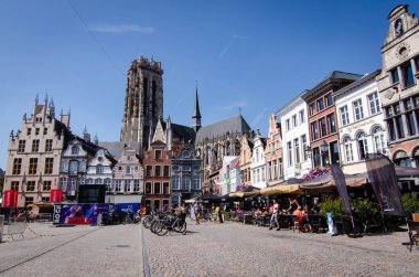 Mechelen, Belçika, Ağustos 2019. Büyük meydan: Grote Markt. Katedralin çan kulesi buradaki en güzel binaların ön cephesinde duruyor. Restoranlar ve insanlar.
