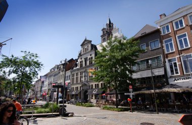 Mechelen, Belçika, Ağustos 2019. Tarihi merkezde, alışveriş caddesinde, tarihi binaların güzel cepheleri marka dükkanlarını çerçeveliyor. Güzel güneşli yaz günü.