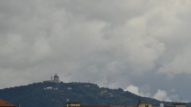 Torinóban, Piemontban, Olaszországban. 2019. május. Egy esős tavaszi napon, a Superga Bazilika mögül sötét felhők csoportjai haladnak át a dombon és ereszkednek le Torino felé. Időeltolódás 4K felbontásban. — Stock videók