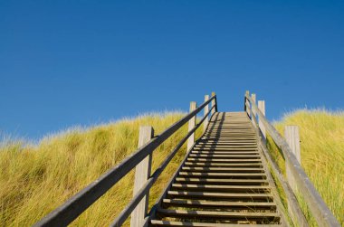 Westkapelle, Hollanda, Ağustos 2019. Bu bölgedeki plajlar geniş ve temiz. Onları çevreleyen kum tepelerini aşmak için, özel ahşap merdivenler sahile kolayca ulaşmamızı sağlıyor..