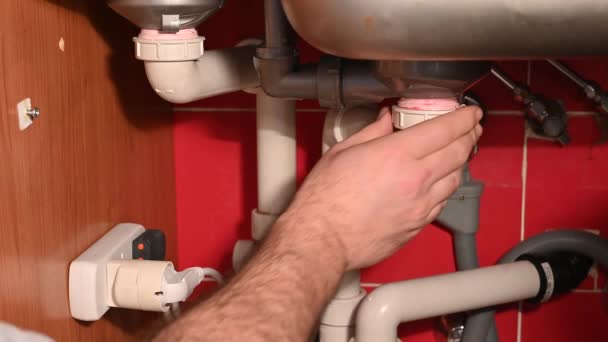 台所の流しの下の排水回路を点検しなさい 配管の気密性をチェックし 不要な漏れがないか黄色の布でチェックします — ストック動画