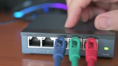 Bir yönlendiricinin yakın plan görüntüsü: üç kırmızı, yeşil ve mavi ethernet kablosunun bağlantıları test edilir. Kablolama kavramı, internet ağı, İnternet, bakım ve işletim ile çalışma.