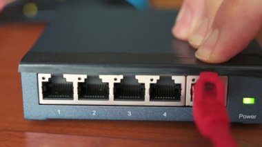 Bir yönlendiricinin yakın çekim görüntüsü: üç kırmızı, yeşil ve mavi ethernet kablosu birbirine bağlıdır. Kablolama kavramı, internet ağı, internet ağı ile çalışma.