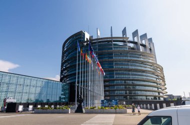 Strasbourg, Fransa. Ağustos 2019. Avrupa Parlamentosu 'nun modern koltuğuna giriş. Avrupa Birliği üye ülkelerinin bayraklarıyla bir sıra bayrak direği, ülkeye girenleri karşılıyor.