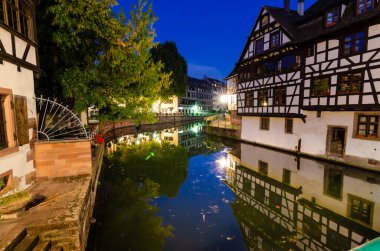 Strasbourg, Fransa, Ağustos 2019. Tarihi merkez hoş ve rahatlatıcı bir bakış açısı sunuyor: karakteristik dönem evleri kanalların su aynasına yansıyor. Mavi saat