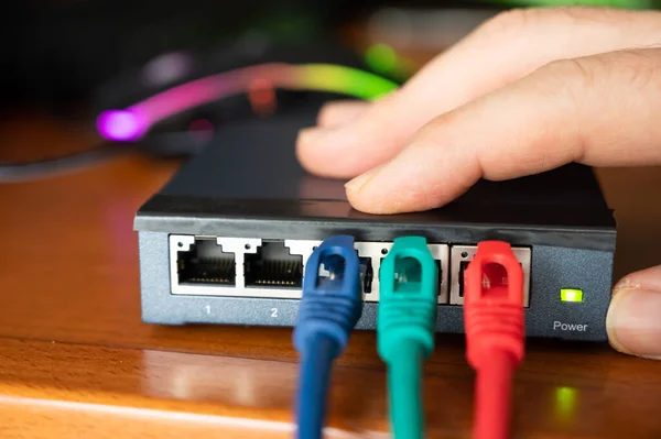 Close-up image of a router: the connections of the three red, green and blue ethernet cables are tested. Concept of cabling, internet network, working with internet, maintenance and operation.