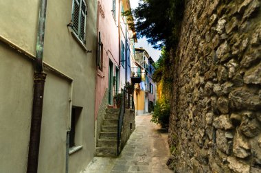 Portovenere, Liguria, İtalya. Haziran 2020. Ülkenin göbeğindeki tipik ikincil ara sokaklara carruggio denir. Sol taraftaki evlerin kapıları dar taş sokağa bakıyor..