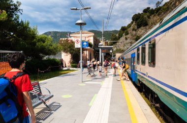 Monterosso, Liguira, İtalya. Haziran 2020. Turistler Cinque Terre 'yi ziyaret etmek için tren istasyonunda trenden inerler. Birçoğunun koronavirüse karşı kendilerini korumak için maskeleri var. Güzel bir yaz günü