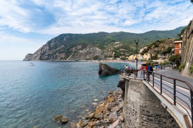 Monterosso, Liguria, İtalya. Haziran 2020. Gezinti güvertesi, banyo tesisleri ve çevresindeki doğa ile güzel bir kumsal manzarası sunuyor. Güzel bir yaz günü