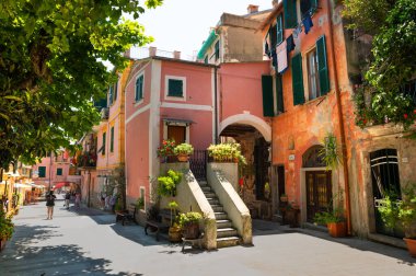 Monterosso, Liguria, İtalya, Haziran 2020. Tarihi merkeze hoş bir bakış: ana caddeye bakan renkli cepheli evler, saksı bitkileri ve ağaçlar manzarayı süslüyor. Turistler.