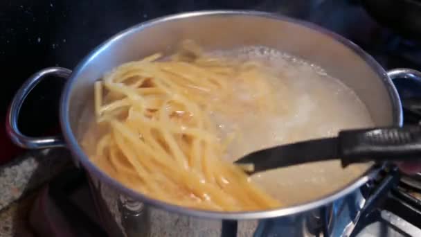 スパゲティを調理して沸騰したお湯の鍋に撮影を閉じます 彼らは料理を容易にするためにひっくり返される イタリアの地中海料理の典型的な料理 — ストック動画