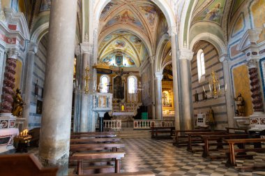 Corniglia, Liguria, İtalya. Haziran 2020. San Pietro kilisesinin içi. Pencerelerden güneş ışınları merkezi kapağı aydınlatmak için içeri girer..