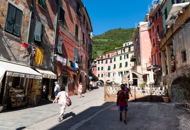 Vernazza, Liguria, İtalya. Haziran 2021. İstasyondan marinaya giden ana cadde. Bazı turistlerin koronavirüse karşı maskesi var, salgından sonra tatilde yeni bir normal kavram..