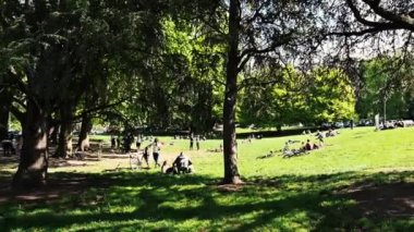 Torino, Piedmont, İtalya. Mayıs 2021. İnsanlar koronavirüs kilitlenmesinden sonraki ilk güzel günün tadını çıkarıyorlar. Valentino parkında, insanlar uzak gruplar halinde çimlerde toplanıyor, yeni bir normal kavram..