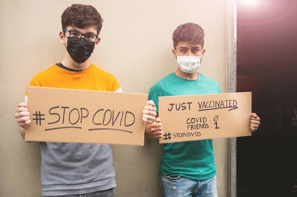 Två Vänner Med Masker Visar Två Skyltar Med Meddelandestoppet Covid — Stockfoto