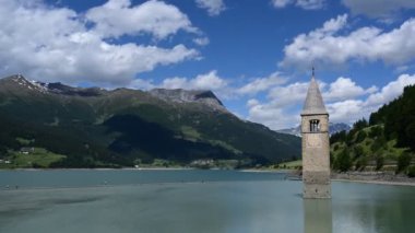 Curon 'un (Graun) eski çan kulesinin güzel bir yaz gününde Güney Tyrol, Resia Gölü' nün sularından yükselen inanılmaz hızlandırılmış görüntüleri..